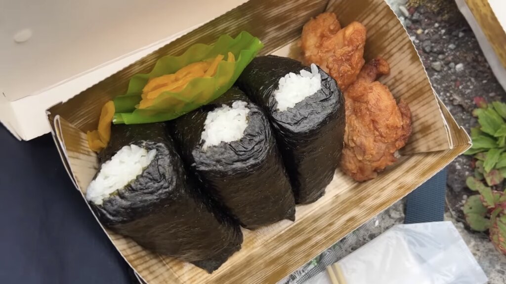 お弁当のおにぎり３つと唐揚げ